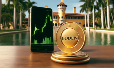 A large, shiny gold coin with "BODEN" engraved on it, standing upright on a table with a smartphone displaying a rapidly rising green candlestick chart, set against a backdrop of Mar-a-Lago resort.